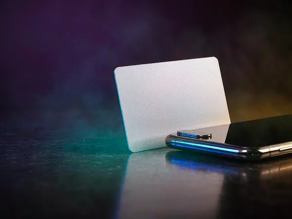 m666 Blank card standing beside a smartphone